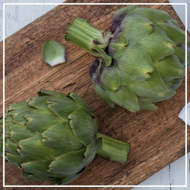 Artichokes from the garden on wooden chopping board